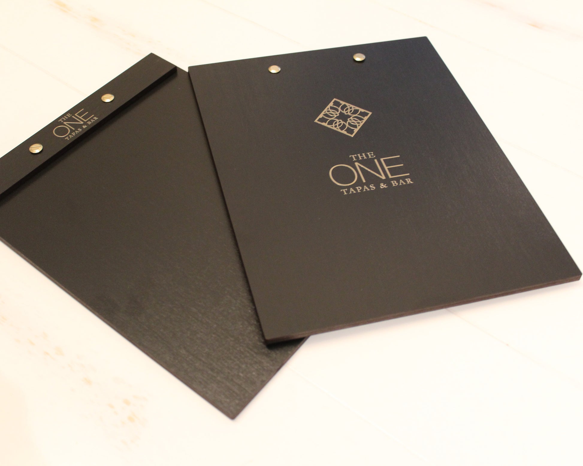 Black wood menu holder with logo printed in gold for upscale hospitality