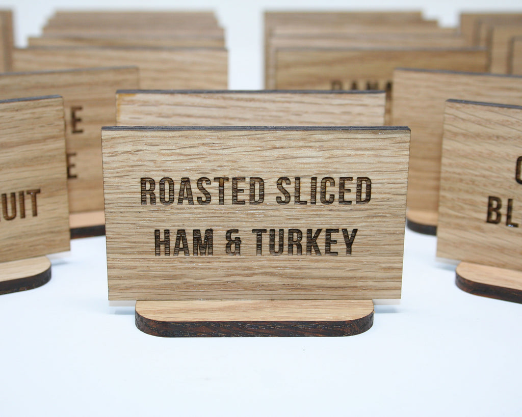 Wooden signs with text indicating types of food on a white background