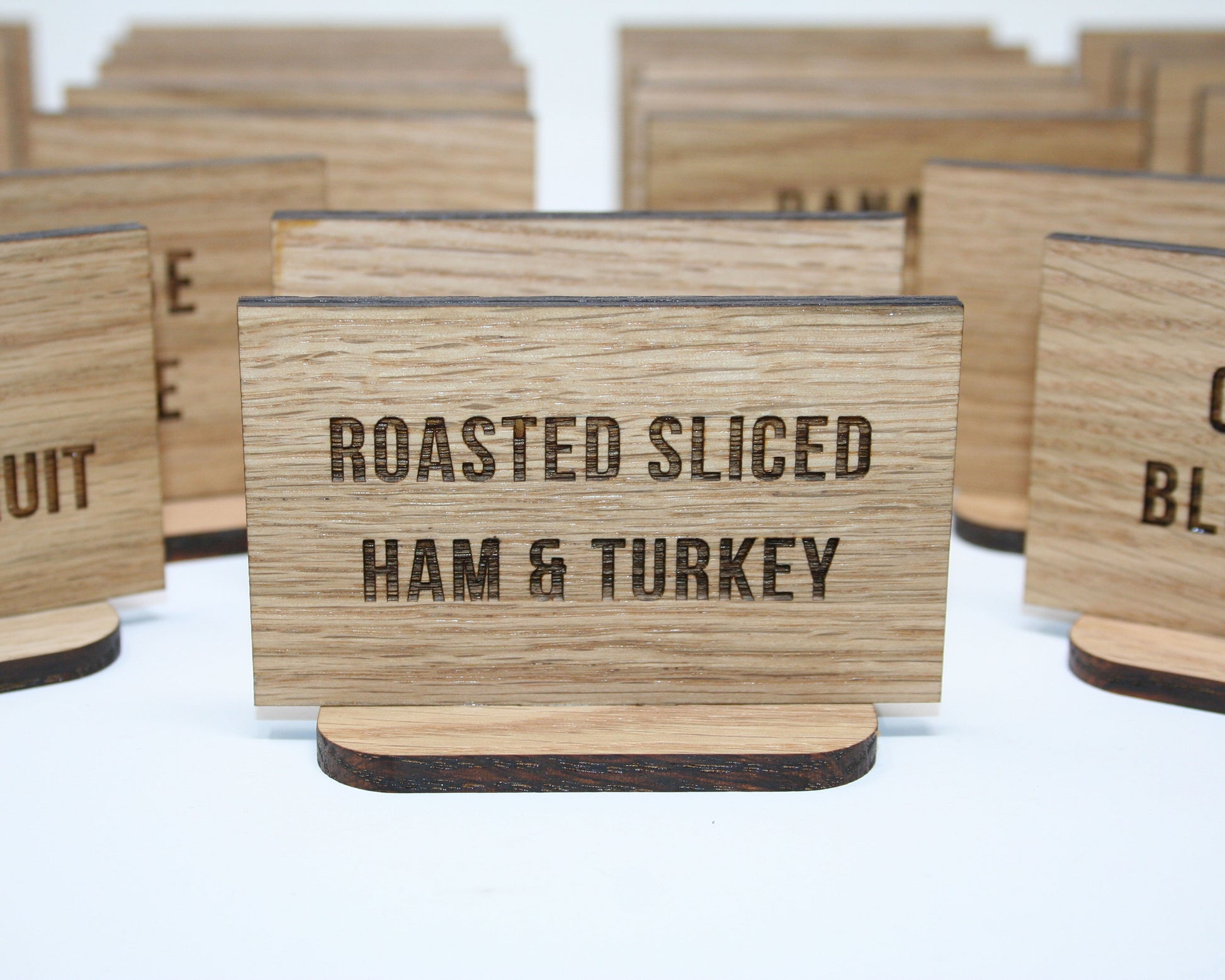 Wooden signs with text indicating types of food on a white background
